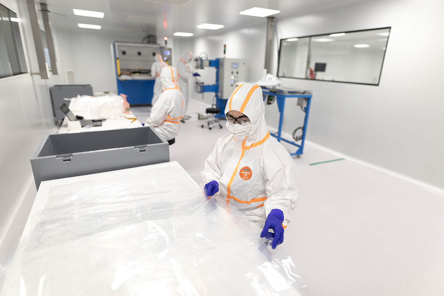 Gowned operators handling a single-use bag in a cleanroom